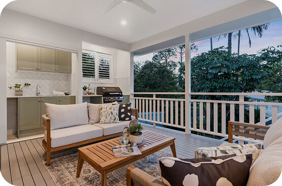 Covered outdoor deck with seating area and white railing