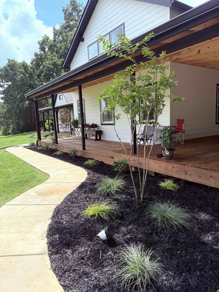 Custom covered front porch with wood decking and landscaped walkway