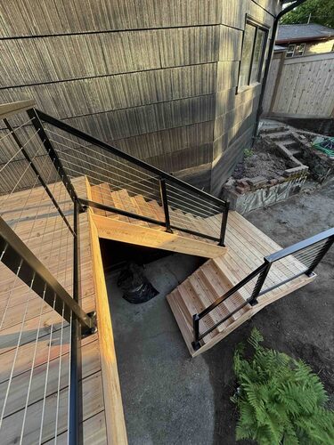 Custom deck stair landing with cable railing and wood framing