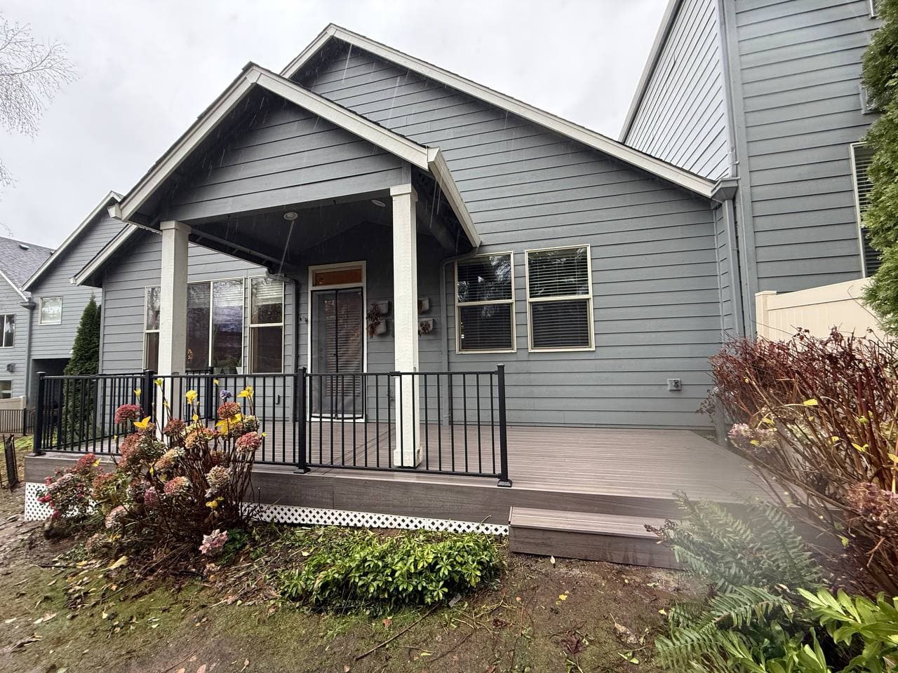 Deck with black metal railing by house