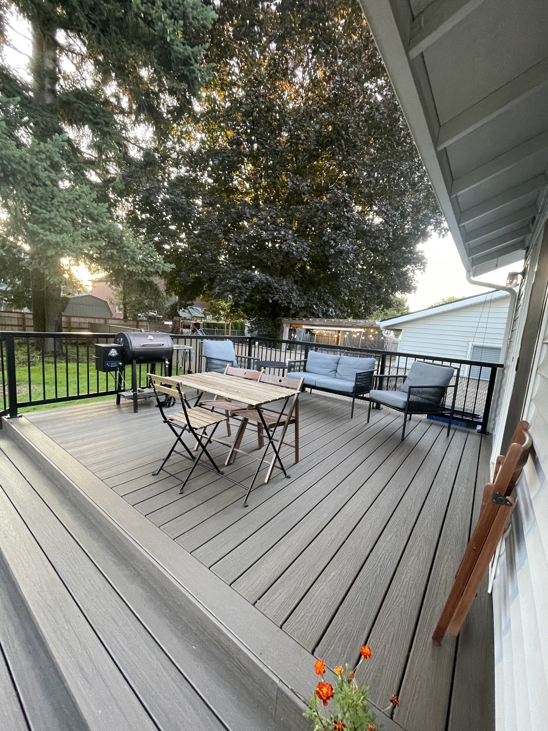 deck with black railing, patio seating, and grill