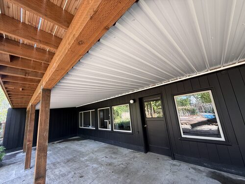 Metal under-deck waterproof ceiling system creating a dry outdoor living space
